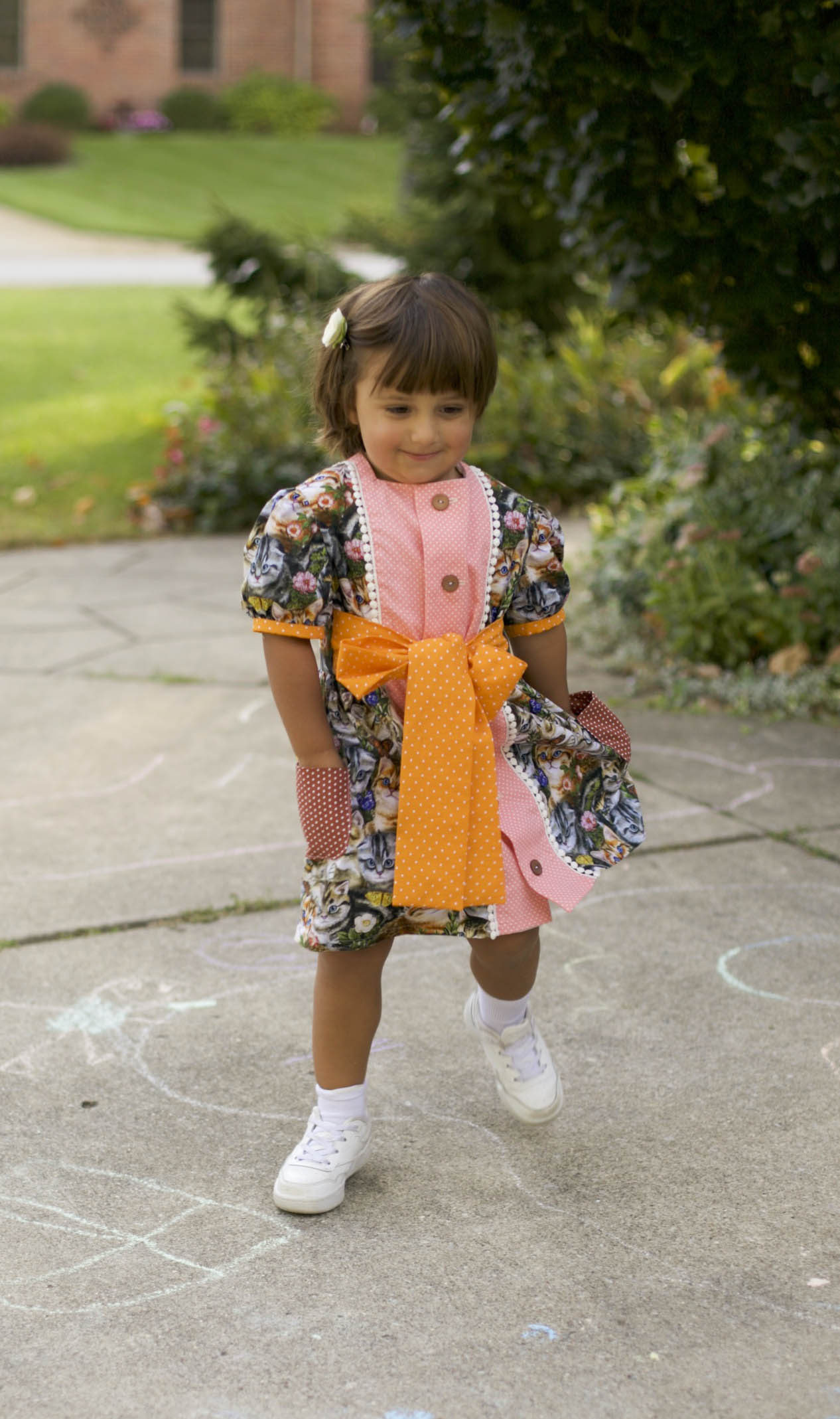 Contrasting polka-dot cotton patch pockets on handmade girls’ kitty cat dress